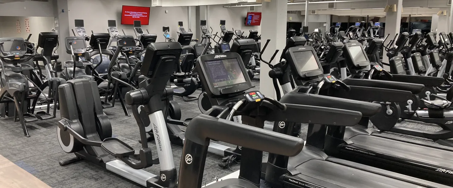 Modern fitness center features various exercise machines, including treadmills and elliptical trainers, designed for a community's health and wellness programs.
